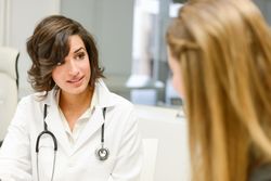 Serious female doctor with female patient in clinic