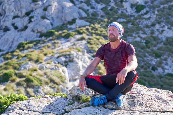 Relaxed traveler taking break on mountain cliff