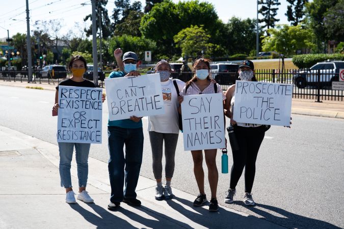 Los Angeles, CA, USA — June 7th, 2020: family poses with protests signs on city street in East LA