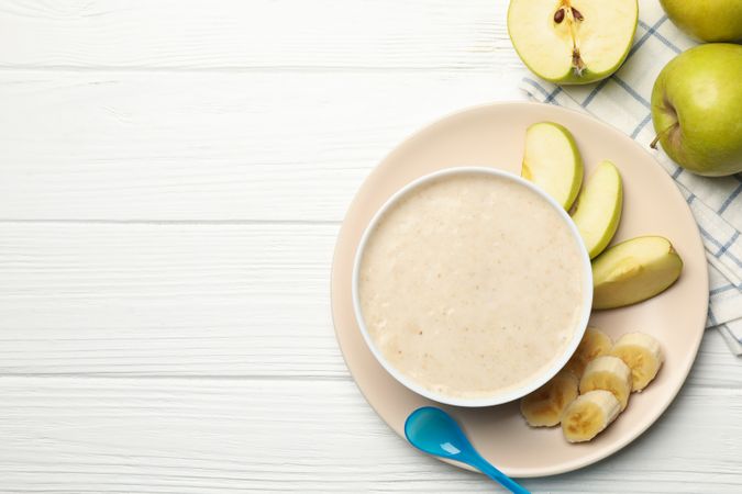Composition with baby food on plain wooden background