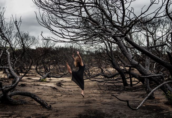 Woman dancing between dry trees