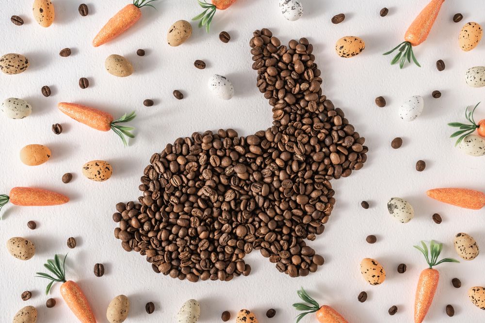Coffee beans in bunny shape with decorative eggs and carrots