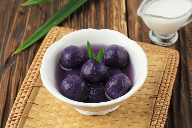 Bowl of purple sweet potato balls with palm sugar and coconut milk sauce