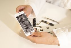 Crop hands showing broken smartphone display