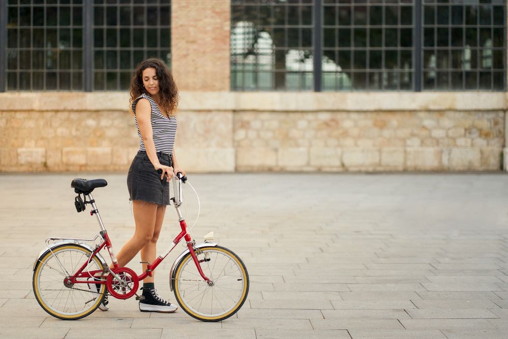 a young woman rides her bicycle across a pedestrian plaza with h