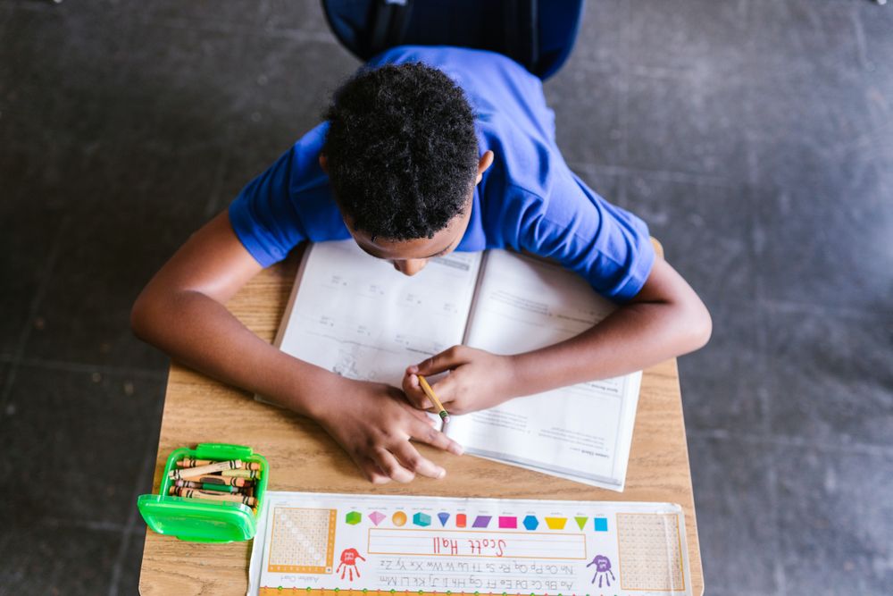 Top view of a boy solving math homework