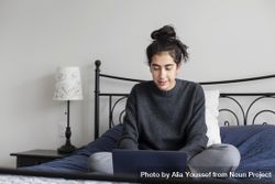 Young female on her bed using a laptop 5rEkn0