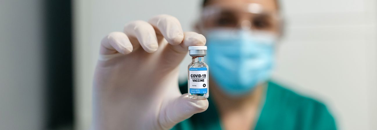 Female laboratory technician showing vial of coronavirus vaccine