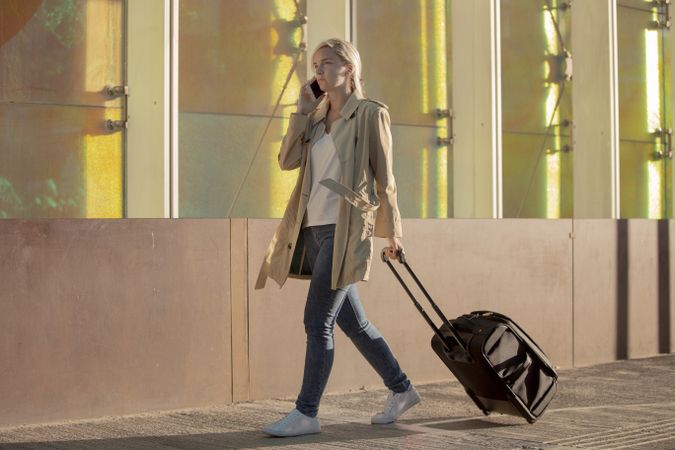 Traveling woman with luggage walking near an airport