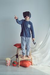 Adorable preteen boy in VR goggles and headphones with joystick