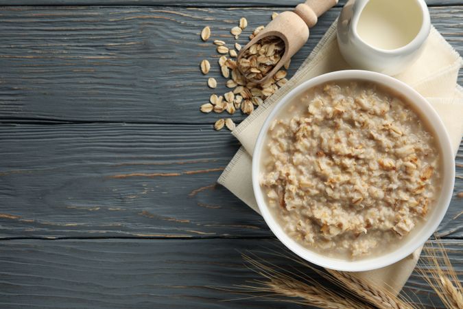 Composition with oatmeal porridge on wooden background. Cooking breakfast