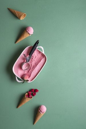 Raspberry ice cream surrounded by waffle cones