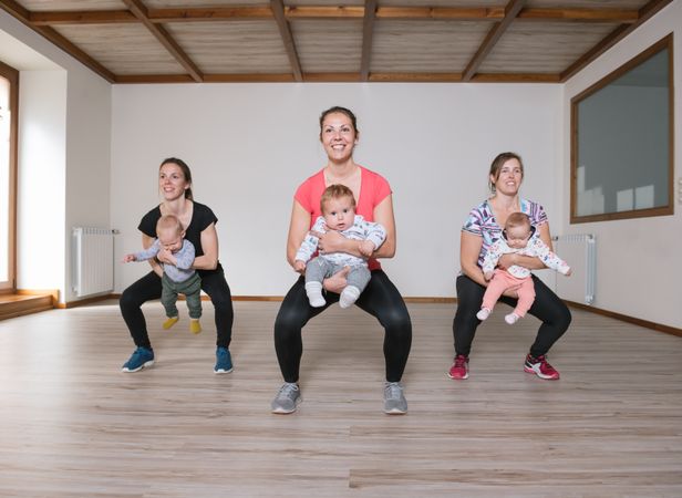 Mothers lifting babies in gym