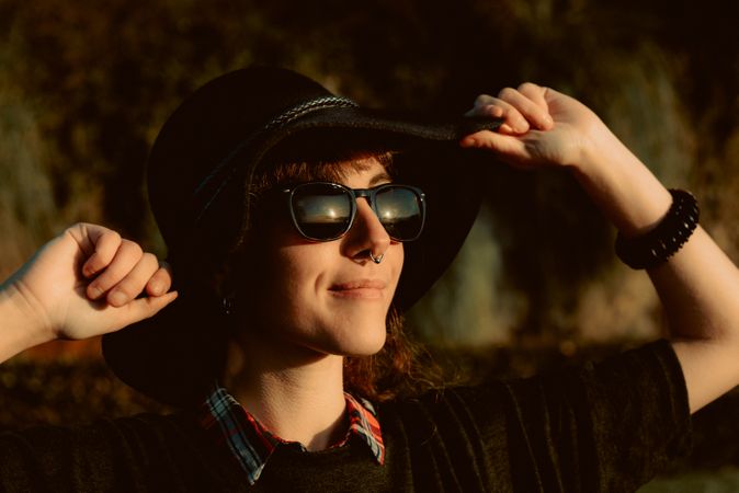 Stylish young woman in felt hat outdoors