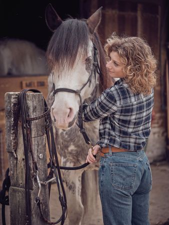 Woman near horse with halter