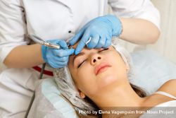 Woman having facial beauty treatment with instrument on her forehead 5X9KP4