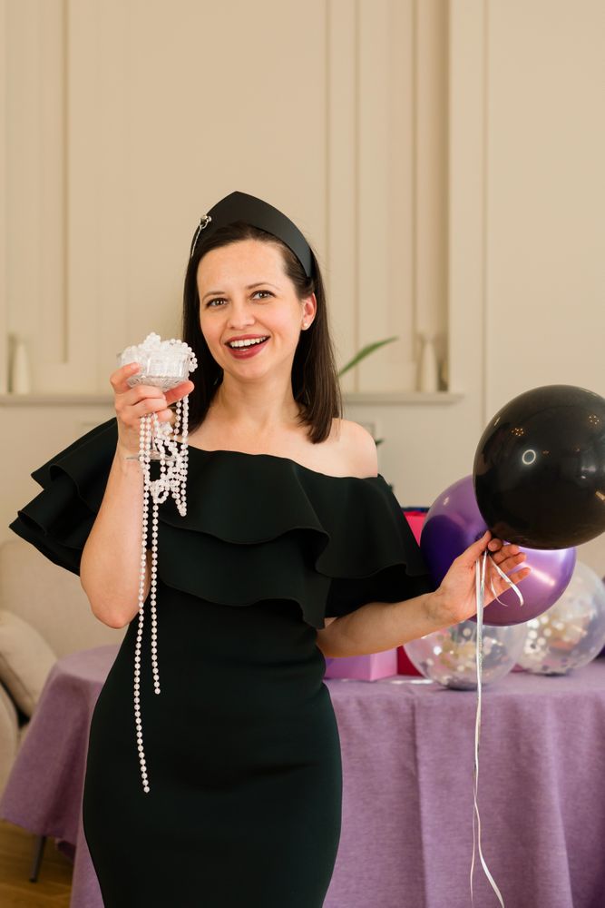 Woman holding jewelry and balloons, birthday party.