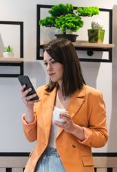 Crop woman using smartphone in cafe