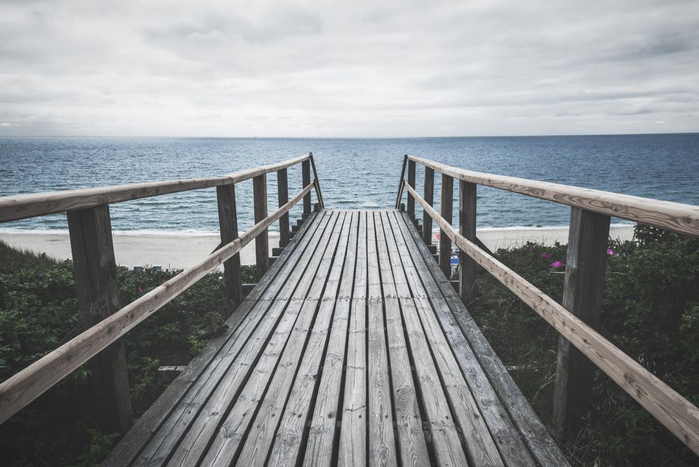 Wooden footpath towards sea on on a rainy summer day