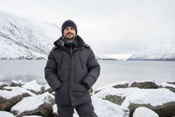 Man on rocky coast looking at camera