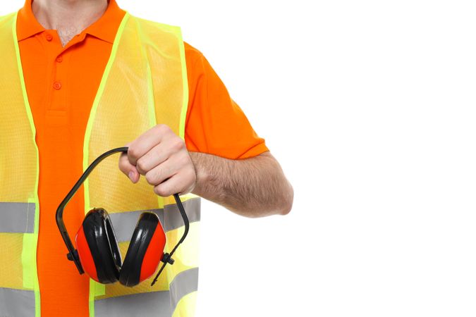 Civil engineer holds protective ear muffs, isolated on light background