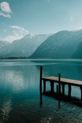 Lonely empty pier in turquoise water along mountain