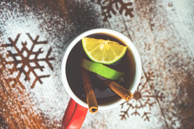 Top view of warm Christmas drink with citrus slice and cinnamon stick