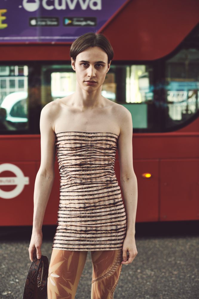 London, England, United Kingdom - September 18 2021: Person in form fitting shirt in front of a bus