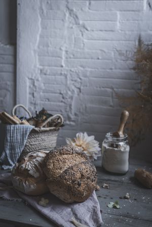 Fresh bread on served table and bunch of dry plant hanging on thread