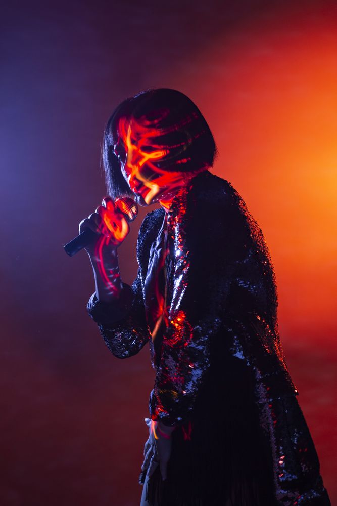 Stylish woman singing on stage