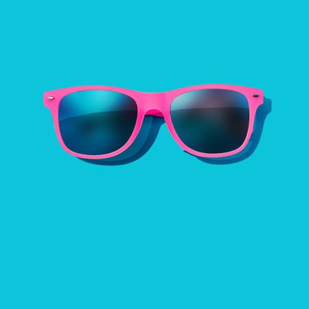 Pink sunglasses on blue background
