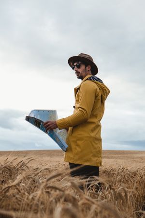 Traveler with map standing in field