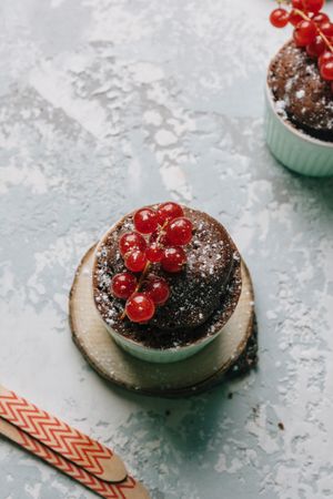 Chocolate cakes in the cup with currants and sugar glass.