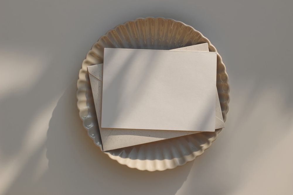 Blank horizontal greeting card mockup with beige envelope on plate