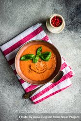Top view of delicious tomato soup with oil garnish and basil leaves 4BaVDe