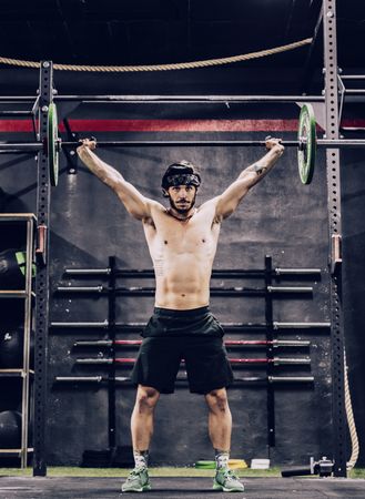 strong and athletic man doing barbell workout in modern gym