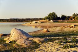 Picturesque view of lake with countryside route, fir forest and hills in Valmayor lake Spain