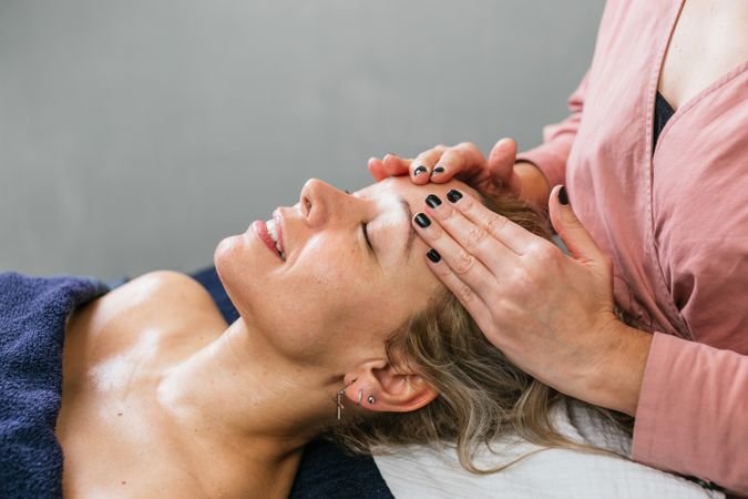 Anonymous masseuse doing massage for woman in spa salon