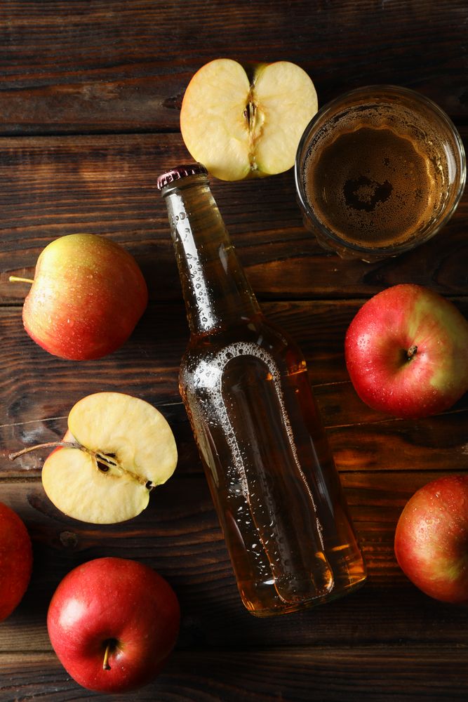 Composition with cider and apples on wooden background