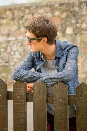 Hipster male with sunglasses over a fence