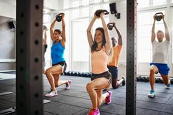 Group of people doing working out in class together with kettle bells