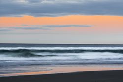 Idyllic seashore with rough waves in sunset