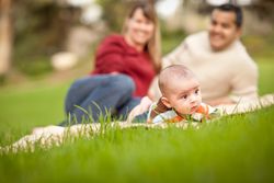 Happy Crawling Baby Boy and Parents Playing in the Park