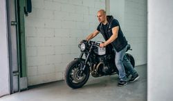 Man with custom motorbike leaving the garage
