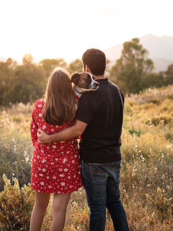 Happy couple with friendly cute dog outdoors