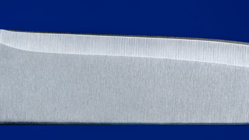 Knife blade close up, isolated on a blue background