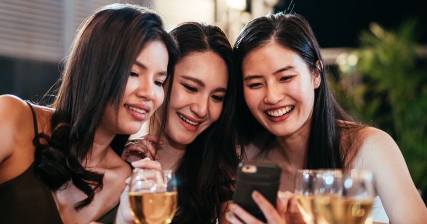 Group of female friends watching video on mobile phone