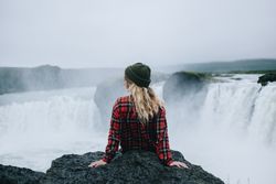 Back of woman sitting over waterfall