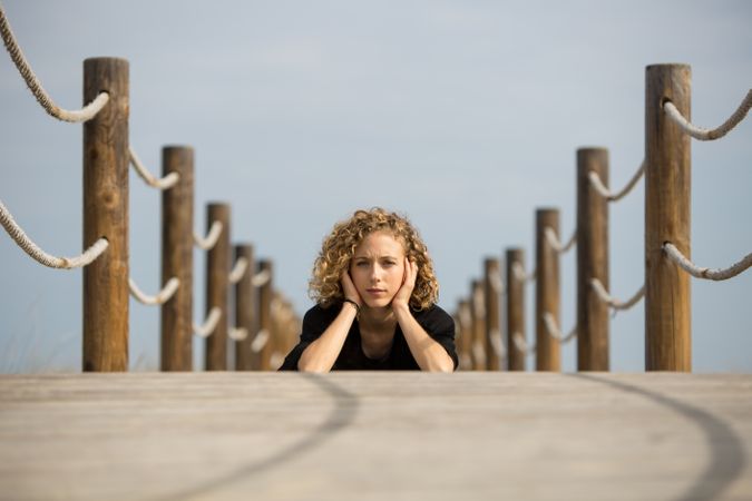 Young woman sitting on footbridge