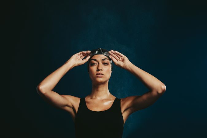 Professional female swimmer on dark background